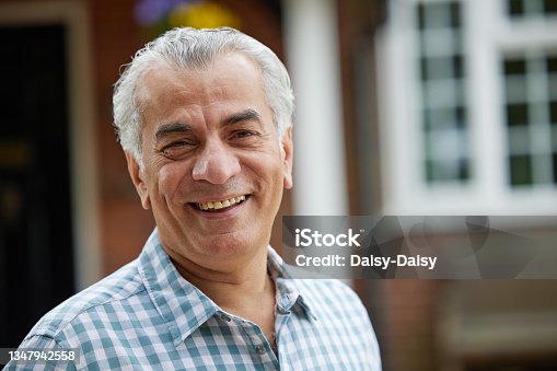 istock Portrait Of Mature Man Standing In Garden In Front Of Dream Home In Countryside 1347942558