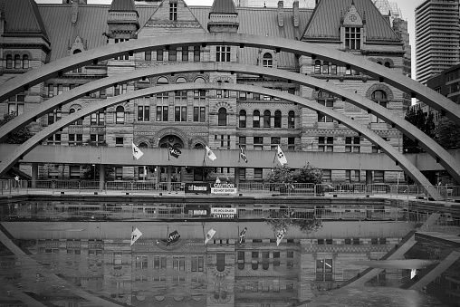 Toronto.Ontario, Canada- October, 21, 2021:  Toronto's old city hall reflecting into the water at Toronto city hall's Nathan Phillips Square.