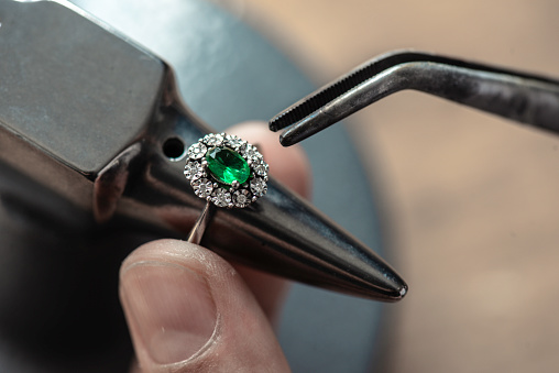 Jeweler making emerald ring.