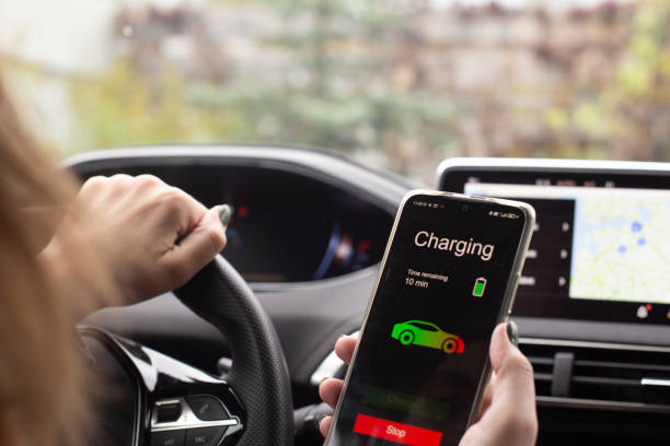 istock Woman sitting electric car charge using mobile application. Modern technology 1347944027