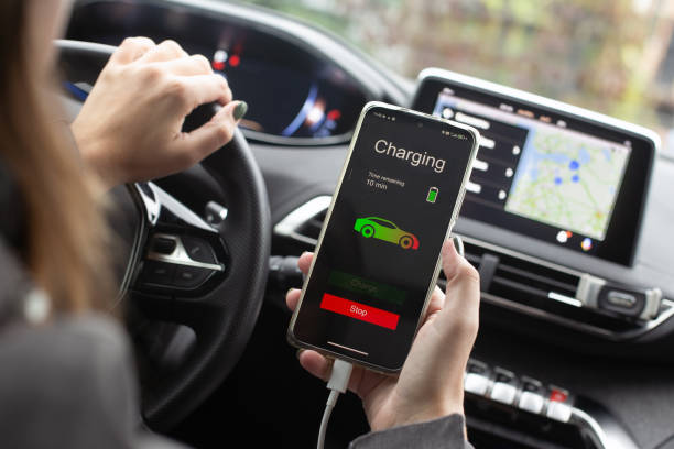 istock Woman sitting electric car charge using mobile application. Modern technology 1347944087