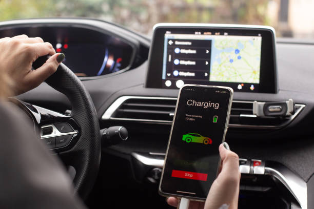 istock Woman sitting electric car charge using mobile application. Modern technology 1347944162