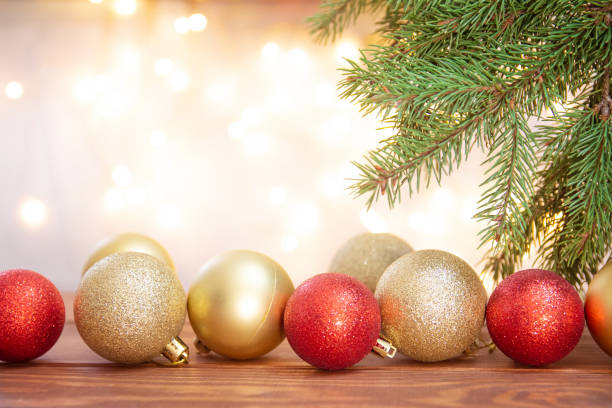 istock Light Christmas background blurred, sparkling. Spruce branches and golden and red Christmas balls on wooden boards on bokeh background. Copy space. Greeting card, happy new year and merry Christmas 1347945528