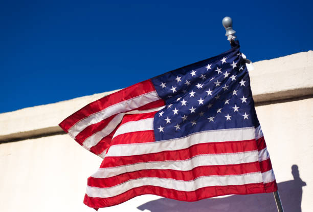 istock Marfa, TX: US Flag Blowing Against White Building, Blue Sky 1347945724