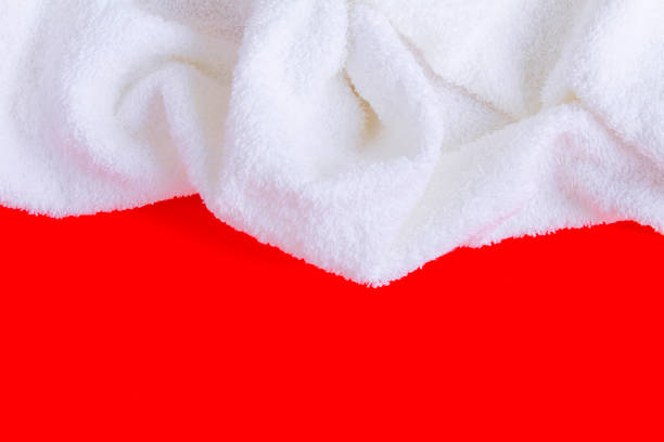 istock White terry towel on the red background. Top view. Copy space. Close-up. 1347945760