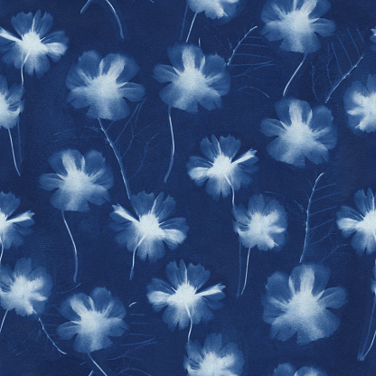 Repeating background pattern of a blue Cyanotype print or sunprint of garden flowers.