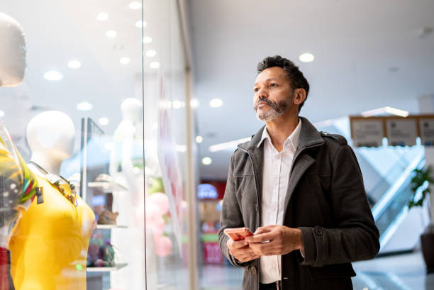 istock Mature man using a smartphone at the mall 1347949377