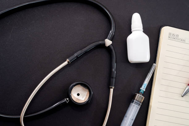 istock on a black background is a stethoscope, nose drops, syringe, notebook and pen 1347949957
