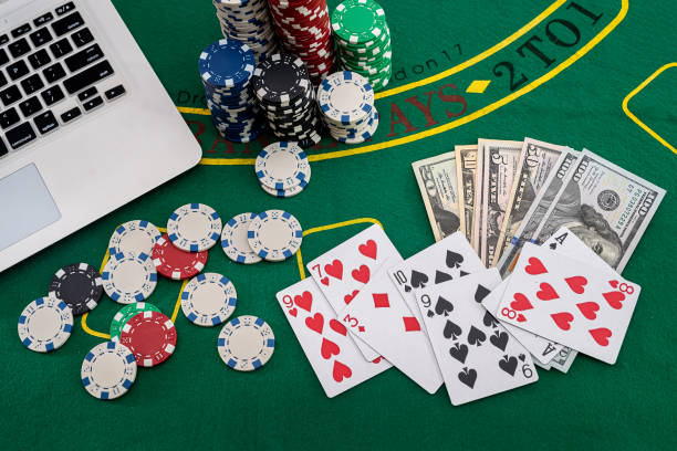 żetony pokerowe z banknotami umieszczonymi na klawiaturze laptopa - gambling chip green stack gambling zdjęcia i obrazy z banku zdjęć