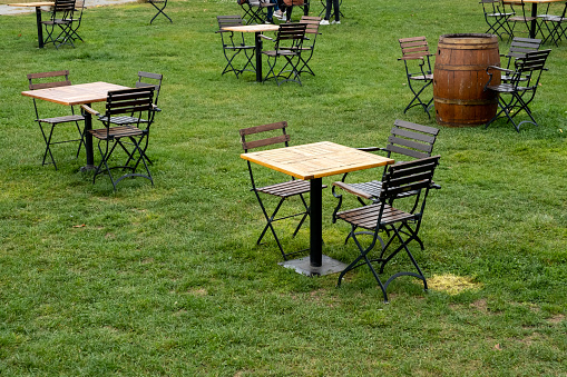 wooden table and iron garden chair on grass floor, front view