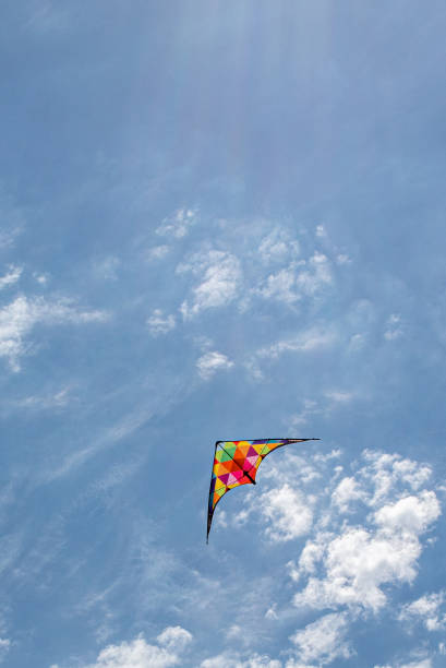 istock Kite flying in the sky with clouds 1347952786