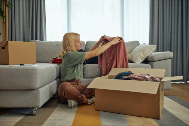 istock Woman sorting clothes from her closet for donation 1347954982