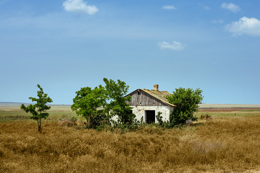 Old abandoned house in a field against the sky.