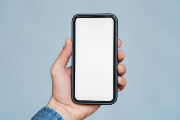 istock Closeup smartphone blank white screen mockup in hand over blue copy space 1347961982