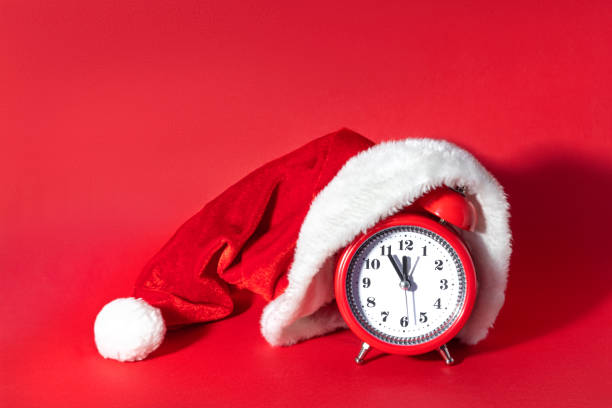 istock Red clock with Christmas Santa hat. Time for Christmas shopping concept. Blank copy space for text. 1347962041
