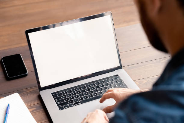 istock Business man freelancer using laptop mockup white screen over shoulder view 1347962087