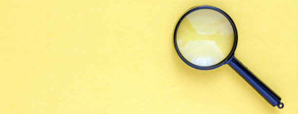 istock close up magnifier glass on yellow background 1347962750