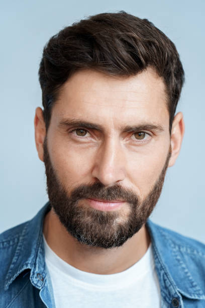 istock Closeup face portrait of bearded man isolated on blue studio background 1347962755