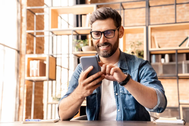 istock Portrait of excited caucasian man using smartphone while resting at home office 1347962910