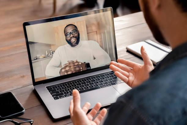 istock Back view of businessman talking with business partner using video call app 1347964427