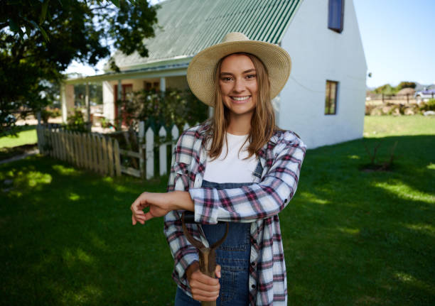 istock Caucasian female farmer standing outdoors leaning on pitch fork 1347966287