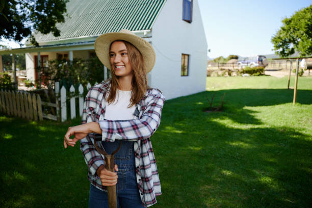 istock Caucasian female farmer standing outdoors leaning on pitch fork 1347966314