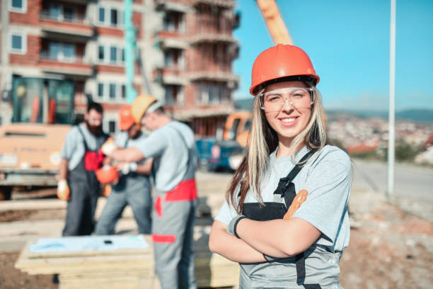istock Portrait Of Smiling Female Civil Engineer Working With Construction Workers On Site 1347971663