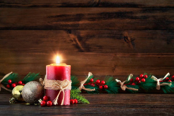 istock Red candle with Christmas decoration on rustic background 1347972841