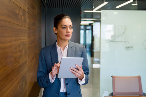 istock Successful business woman working at the office using a tablet 1347972919