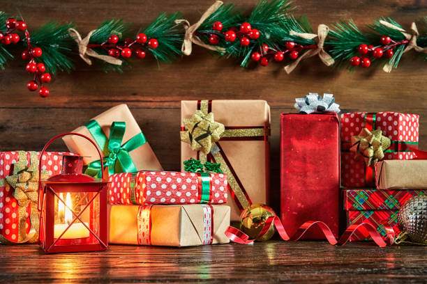 istock Christmas red candle holder with Christmas gifts on rustic background 1347973576