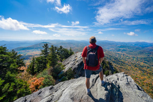 istock Hiker man standing on a cliff edge enjoying scenic view. 1347976566