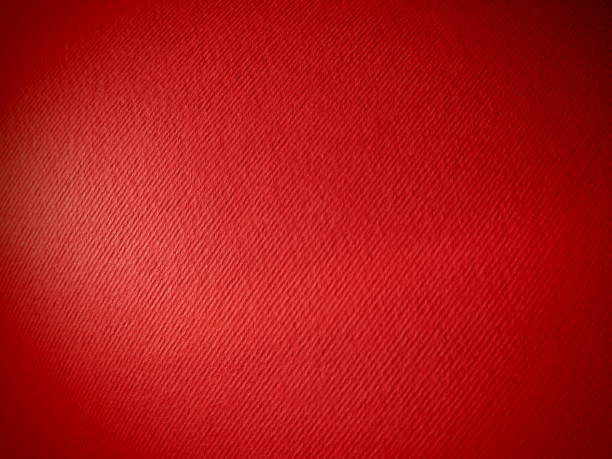 istock Abstract red background with texture. Close-up of paper surface with light and color gradient. Side lighting. Bright crimson backdrop 1347976654