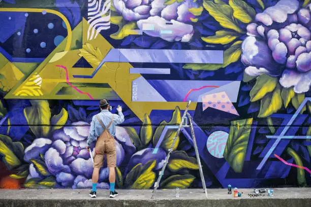 Photo of Full Length Of Graffiti Artist Painting Wall