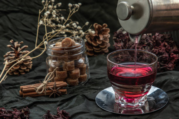 istock Roselle tea (Jamaica sorrel, Rozelle or hibiscus sabdariffa ) is poured from a kettle into glass cup  with dry roselle and brown cane sugar cube. 1347978019