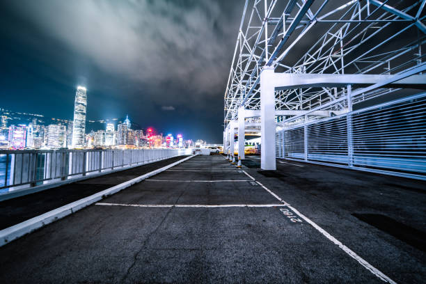 piattaforma di mattoni vuota con lo skyline di hong kong sullo sfondo di notte - blurred motion street city life urban scene foto e immagini stock