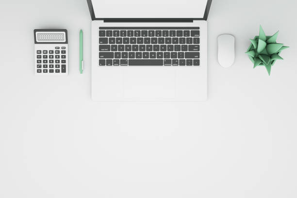 istock Minimalistic office with laptop with blank screen, calculator, computer mouse, Green plant and pen on table. work from home concept. 3D Rendering. top view. 1347992405