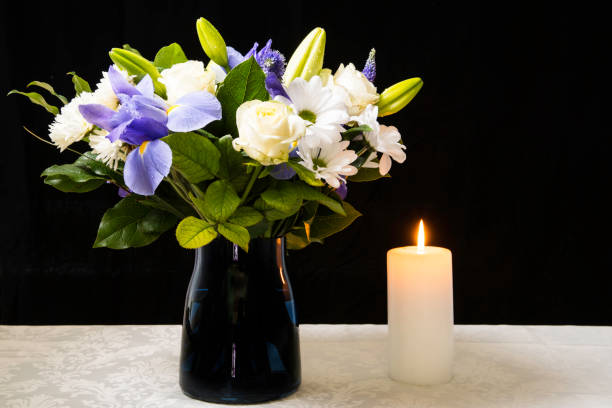 장례 꽃다발 보라색 흰색 꽃과 불타는 흰색 촛불, 복사 공간과 검은 배경에 동정과 애도 개념. - wake 뉴스 사진 이미지