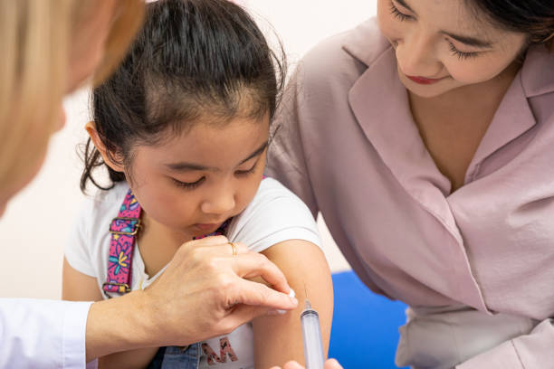 young asian girl get medical vaccine injection from the doctor with her mother sit and hold to support. medical service for young people, kids. - injecting flu virus cold and flu doctors office imagens e fotografias de stock