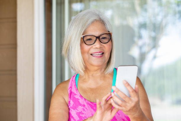 istock Happy Senior Woman using mobile device to text friends 1347996010
