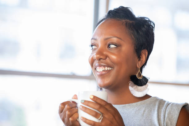 istock Woman holding mug and smiling 1347998246