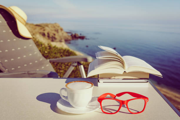 Tropical sea seen from the boat. Book and coffee on table. Reading and relaxing on vacation