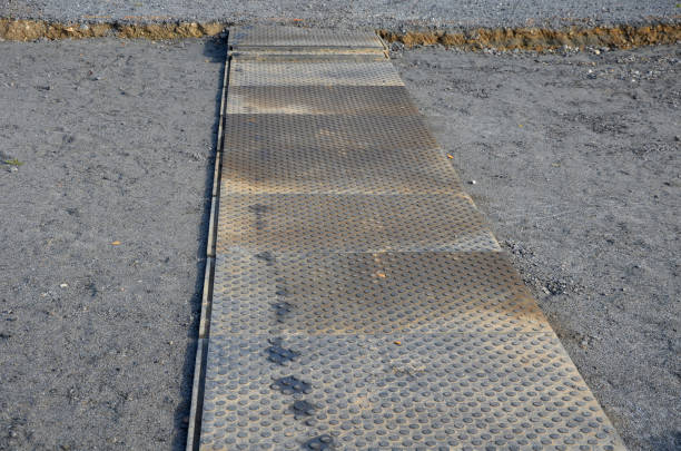 rubber and anti-slip plastic items serve as a temporary sidewalk across the construction site. green carpets serving as a picnic spot on a recycled asphalt surface. prayer rugs