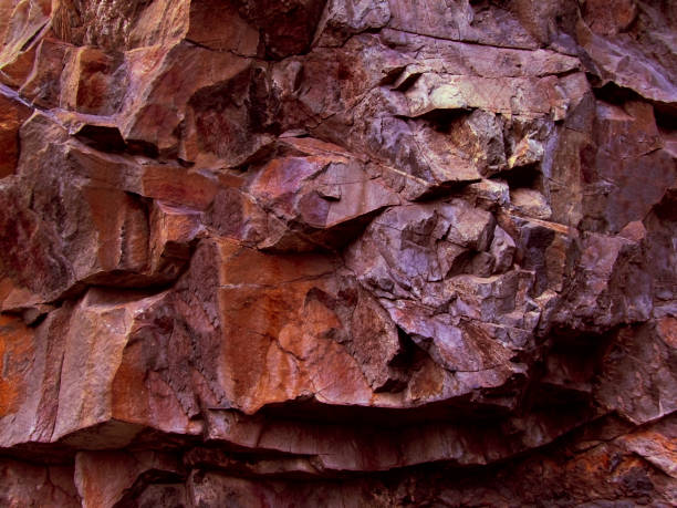 Brown red orange rock texture. Rocky formation. Volumetric stone background for design. Mountain surface. Close-up.