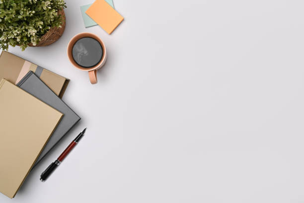 istock Coffee cup, potted plant and notebooks on white table. Copy space. 1348011590