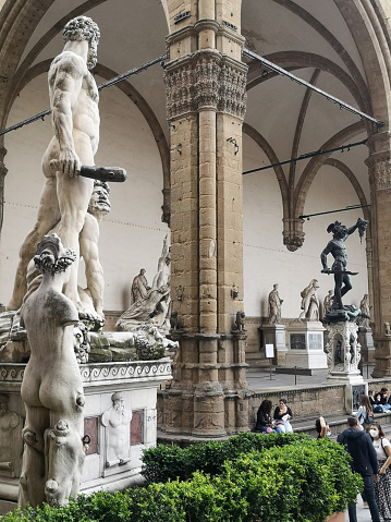 Statues overlooking Piazza della Signoria and the Loggia dei Lanzi. Tourists sightseeing the famous square in Florence, Tuscany.