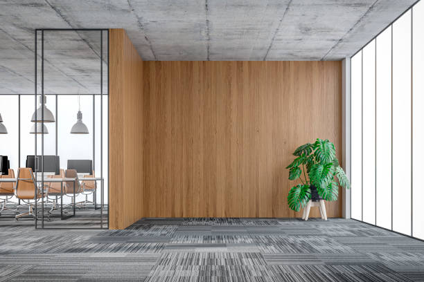 istock Empty office interior: a lounge corner with copy space and wordesks behind glass door 1348015590