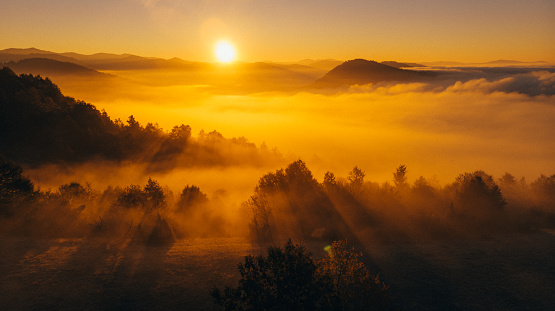 A landscape image of a foggy sunrise