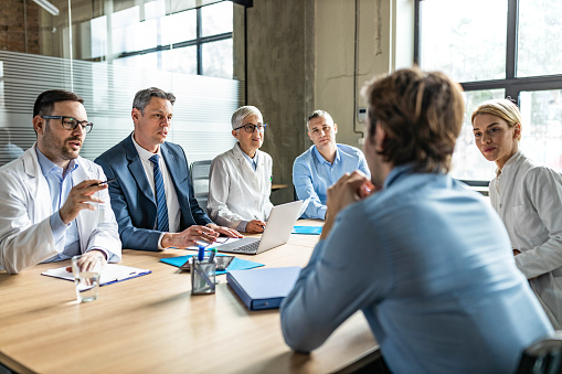 General practitioners and businessmen talking while having a meeting in the office.