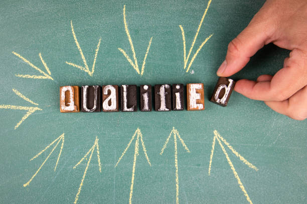 istock Qualified. Text with arrows on a green chalk board 1348018339