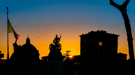 A suggestive sky of a colorful sunset illuminates the sky of Rome and the silhouette of the Altare della Patria and Palazzo Venezia, in the historic center of the Eternal City. Palazzo Venezia was formerly the seat of the embassy of the Serenissima Republic of Venice to the Holy See, at the beginning of the 20th century it was the seat of the fascist regime, while today it is a building owned by the Italian state. The Altare della Patria or Vittoriano is the Italian National Monument built between the Capitoline Hill or Campidoglio (Roman Capitol) and Piazza Venezia in 1885 in honor of the first king of Italy, Victor Emmanuel II. Inside is the grave of the Unknown Soldier, a National Monument dedicated to all the Italian soldiers who died in the war. The Altare della Patria is the setting for all Italian civic celebrations, in particular the National Day of the Republic on 2 June and the Liberation Day on 25 April. In 1980 the historic center of Rome was declared a World Heritage Site by Unesco. Image in 16:9 and High Definition format.